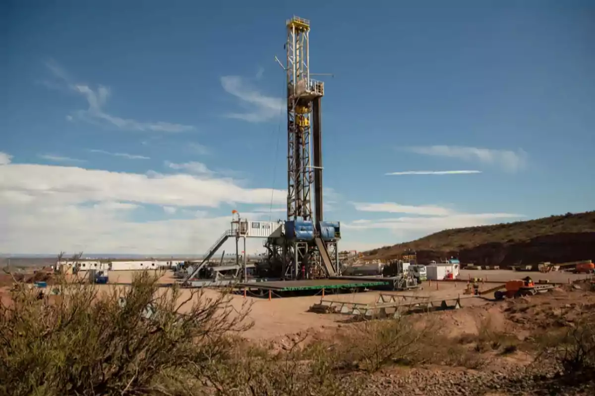 Una plataforma de perforación petrolera en un paisaje árido con cielo despejado.