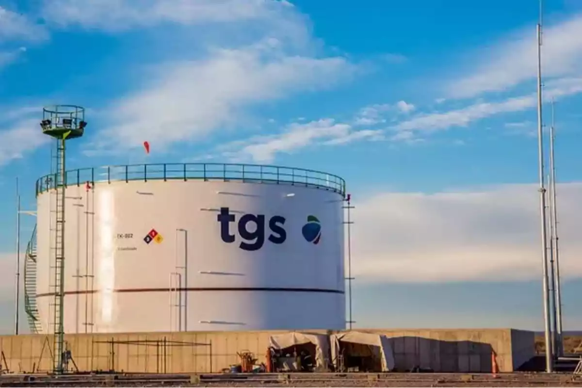 Tanque de almacenamiento de gas con el logo de TGS en un entorno industrial bajo un cielo azul.