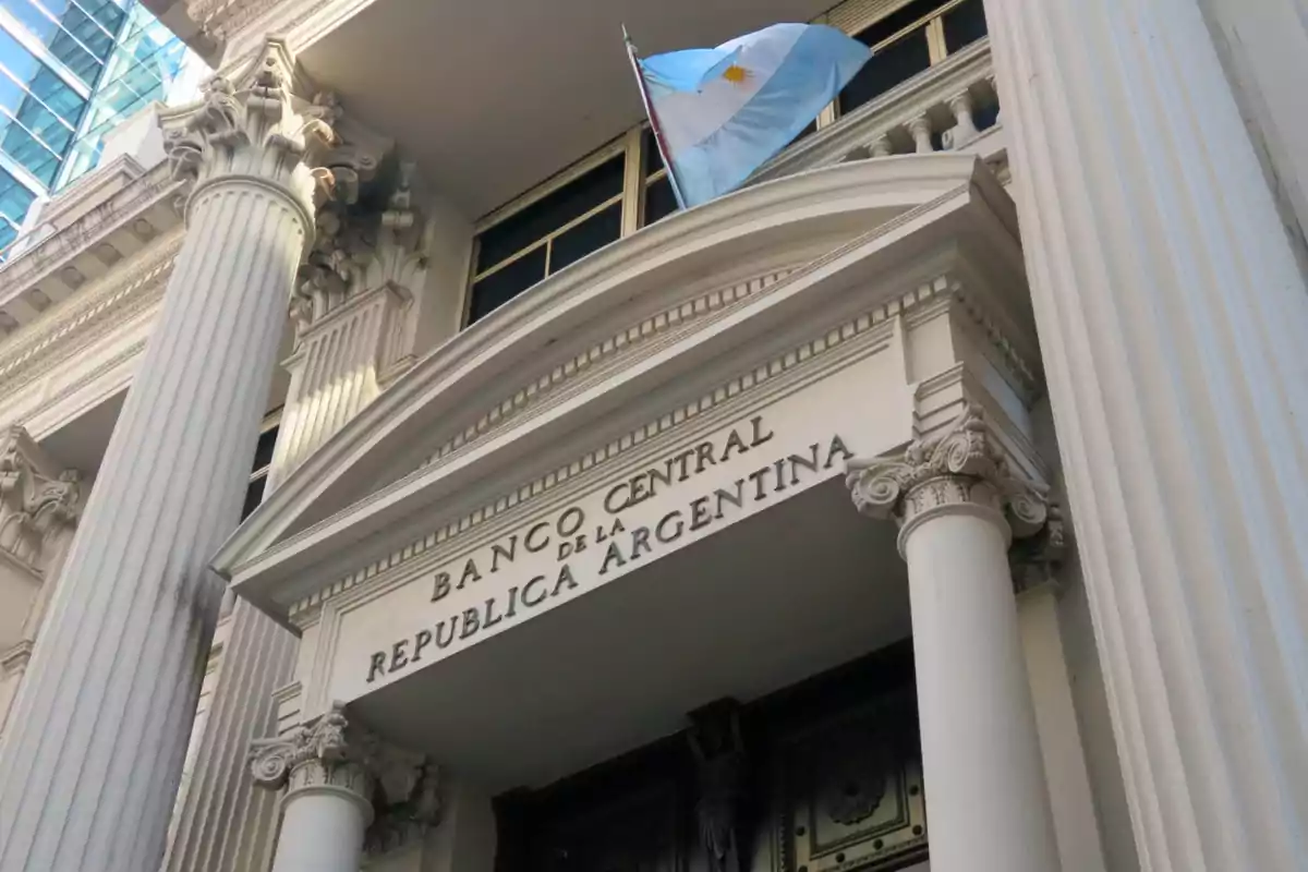 Fachada del Banco Central de la República Argentina con columnas clásicas y una bandera argentina ondeando.