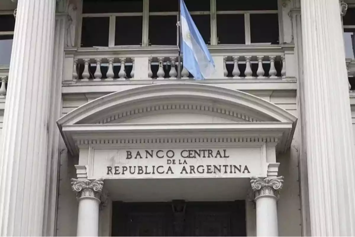 Fachada del Banco Central de la República Argentina con una bandera argentina ondeando.