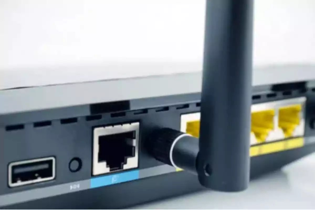 Vista trasera de un router con puertos Ethernet y una antena.