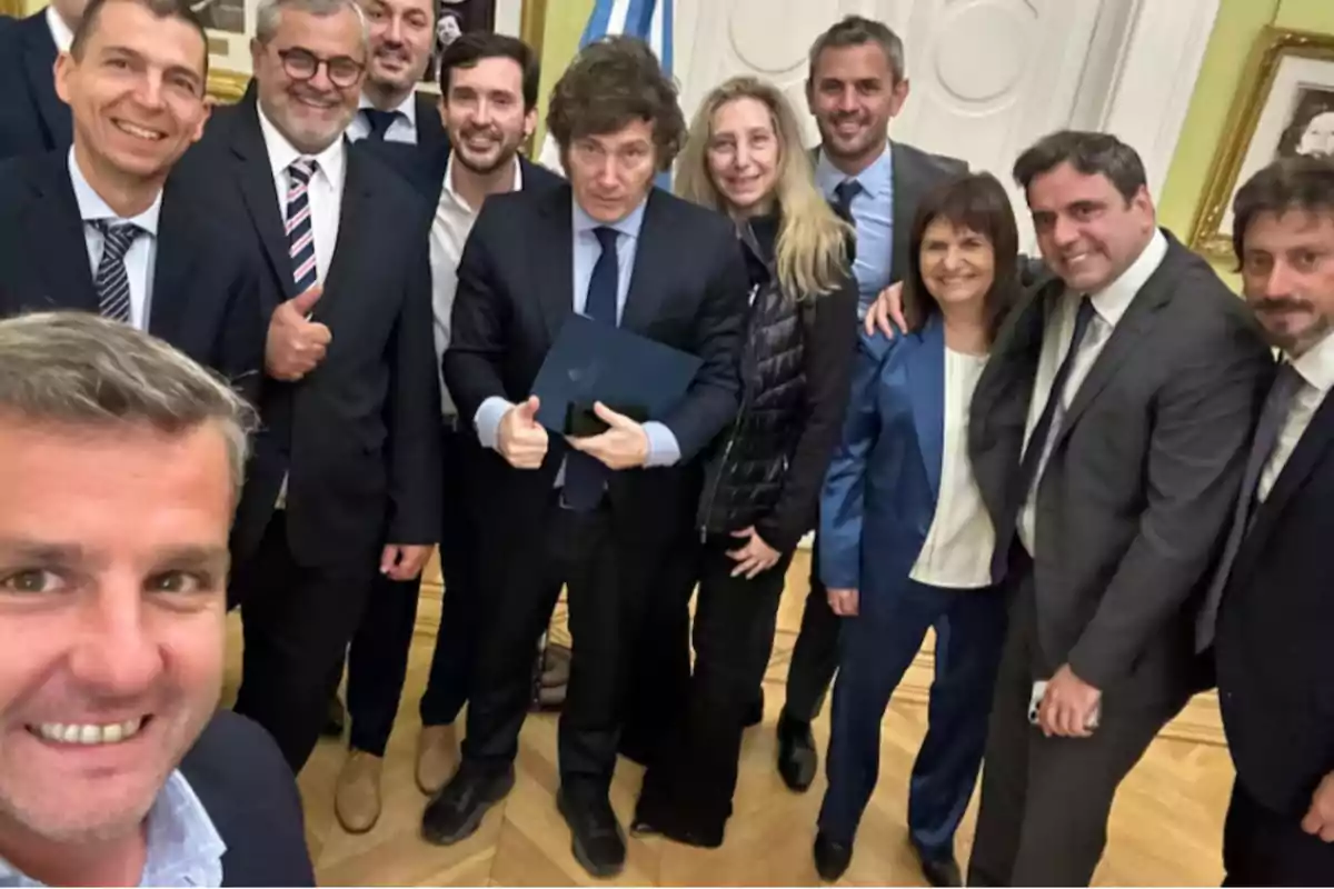 Un grupo de personas vestidas formalmente posando para una foto en un interior elegante.