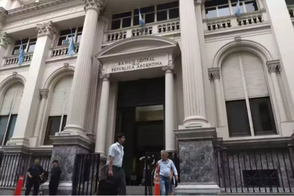 Fachada del Banco Central de la República Argentina con columnas clásicas y personas caminando frente al edificio.