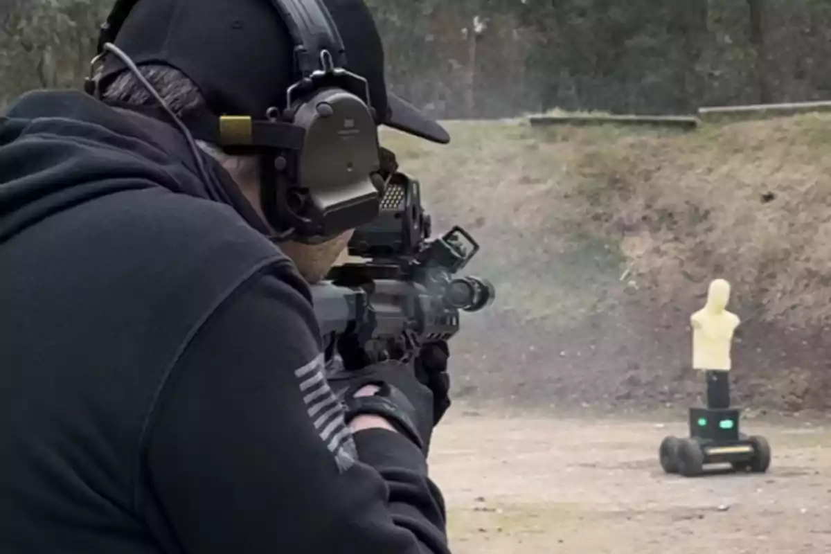 Persona con equipo de protección auditiva y gorra apuntando con un rifle hacia un maniquí de práctica en un campo de tiro.