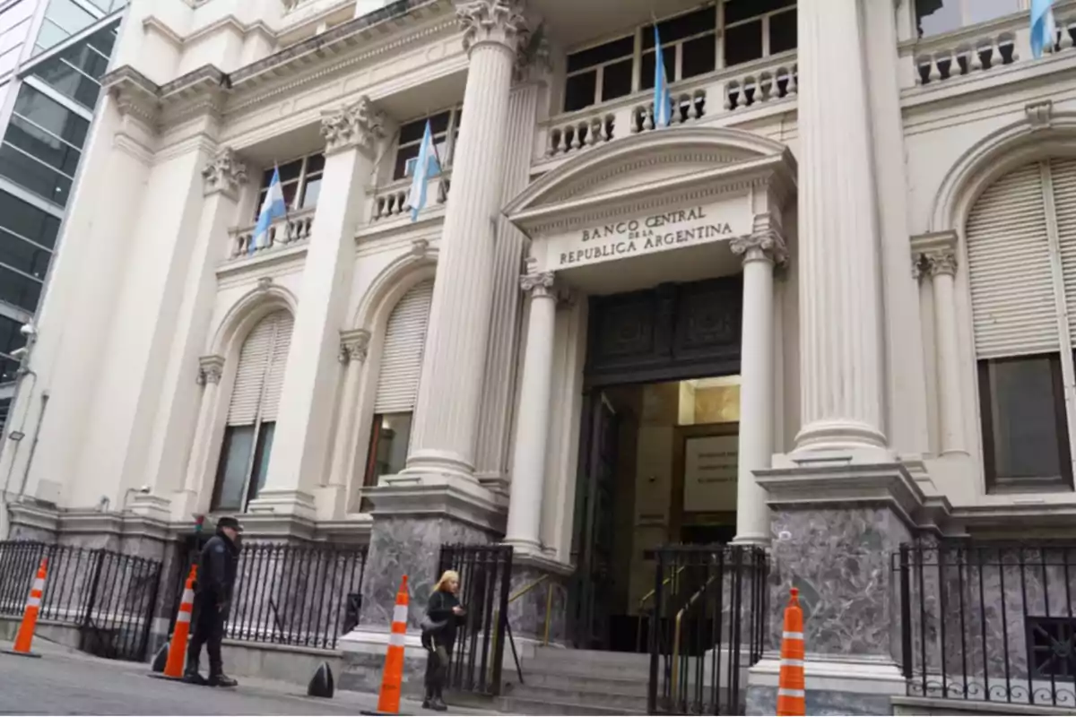 Fachada del Banco Central de la República Argentina con columnas y banderas en la entrada principal.