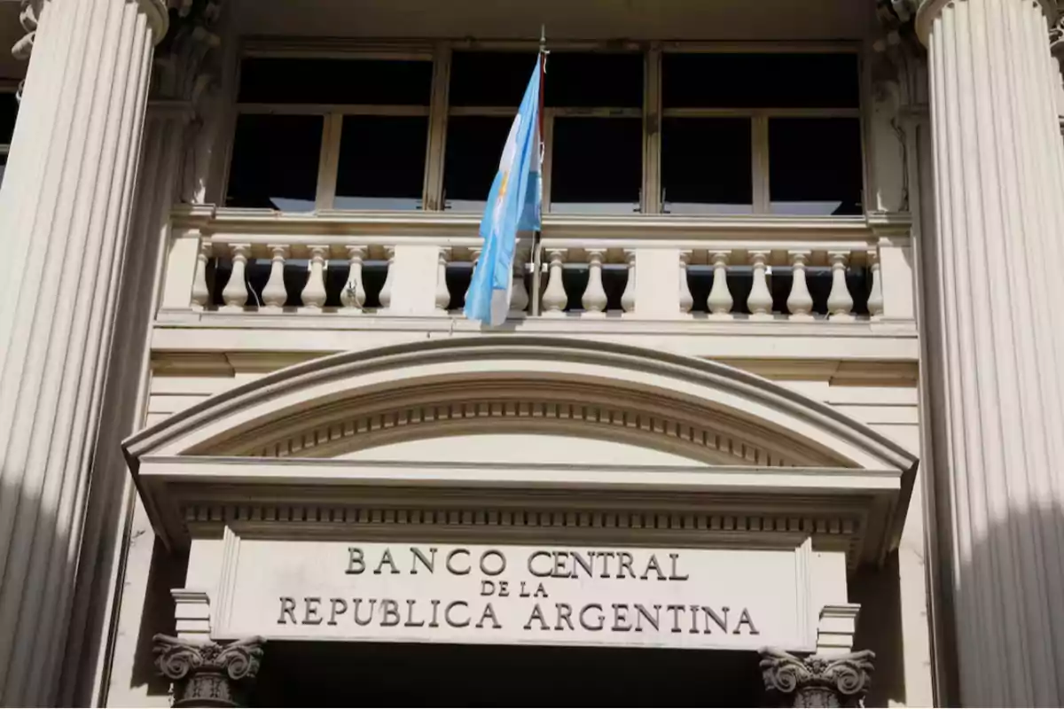 Fachada del Banco Central de la República Argentina con una bandera argentina ondeando.