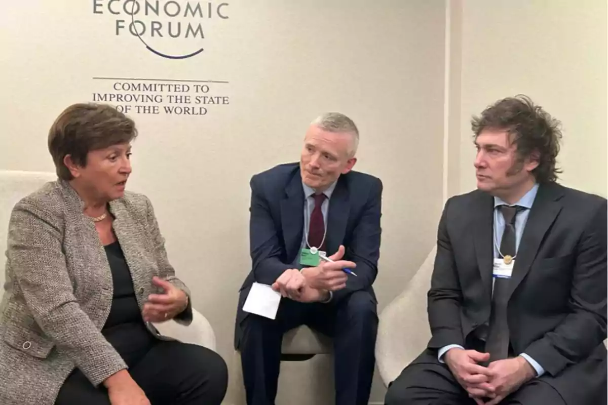 Tres personas sentadas conversando en un evento del Foro Económico Mundial.