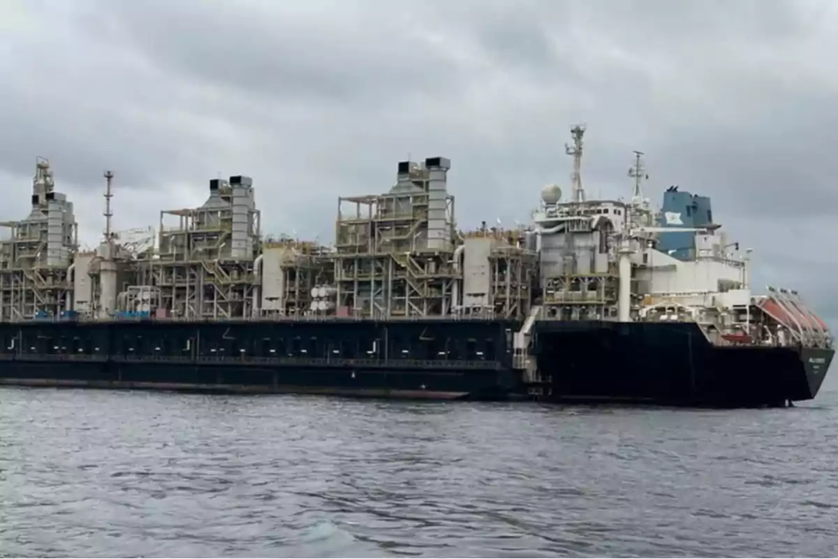 Un gran barco industrial en el agua bajo un cielo nublado.