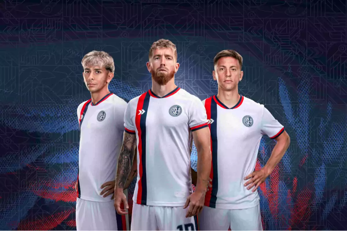 Tres jugadores de fútbol posan con el uniforme blanco de San Lorenzo, que tiene detalles en rojo y azul, sobre un fondo con patrones geométricos.