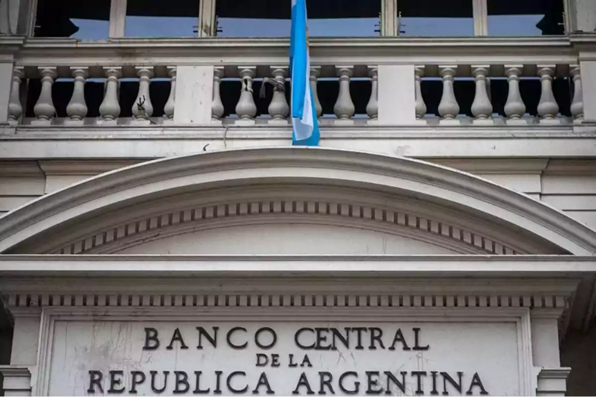 Fachada del Banco Central de la República Argentina con una bandera argentina ondeando.