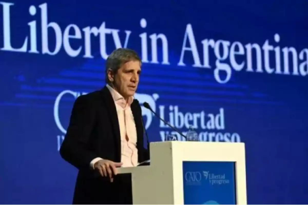 Hombre hablando en un podio con fondo azul que dice "Liberty in Argentina".