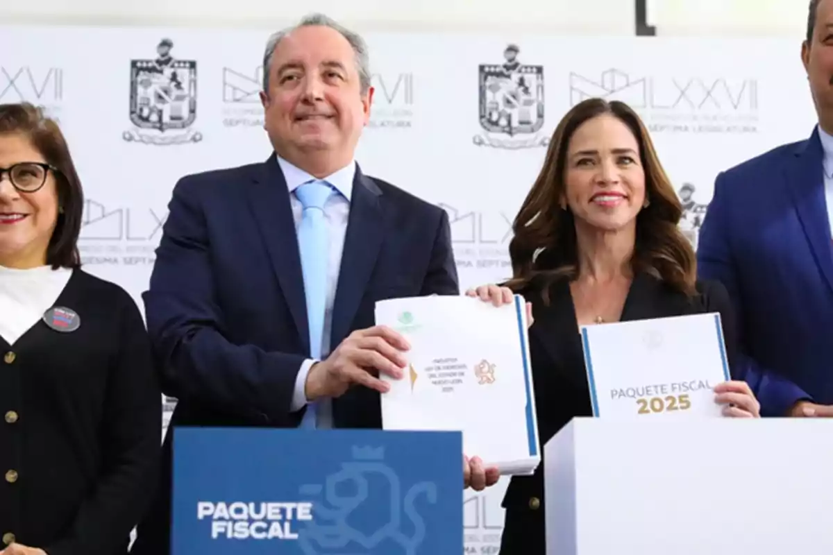 Personas posando con documentos del "Paquete Fiscal 2025" en un evento oficial.