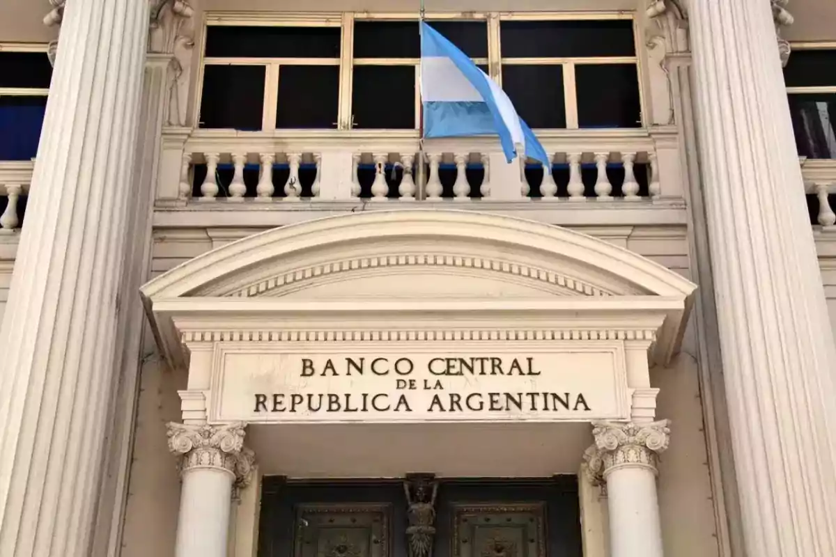 Fachada del Banco Central de la República Argentina con una bandera argentina ondeando.