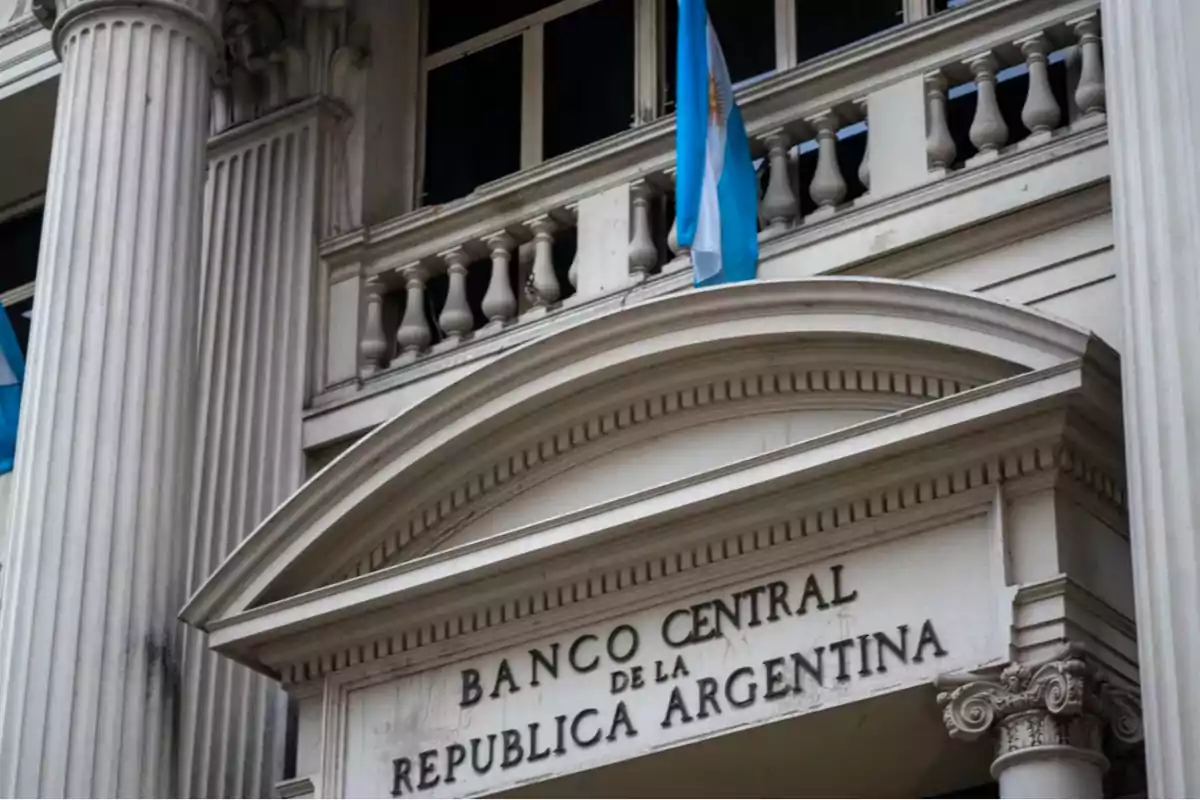 Fachada del Banco Central de la República Argentina con una bandera argentina ondeando.