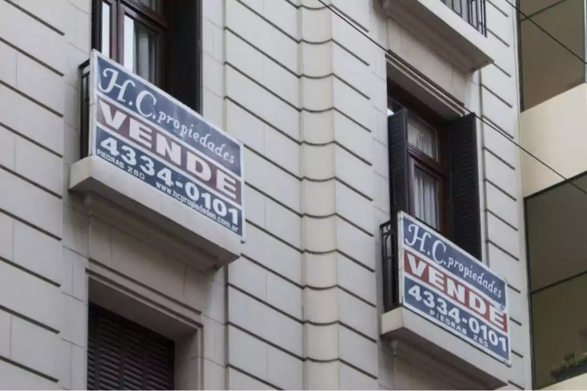 Building with property for sale signs on the balconies.