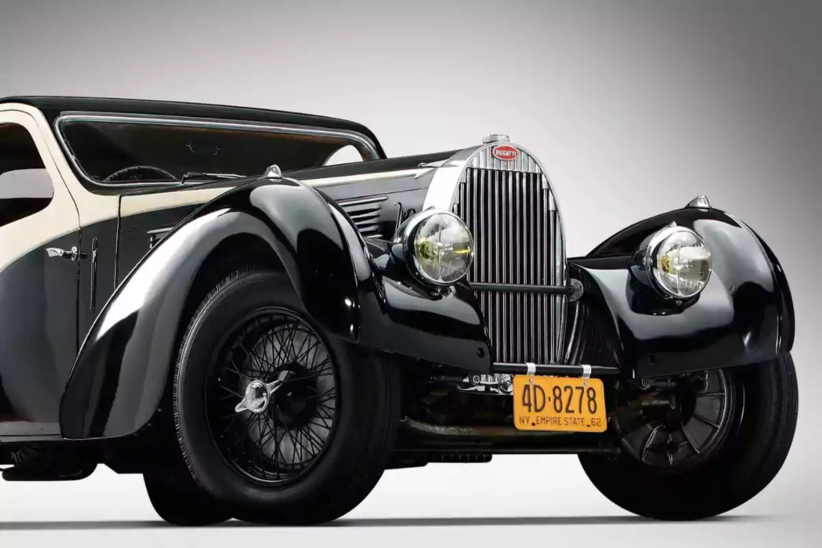 Un automóvil clásico Bugatti negro con un diseño elegante y detalles vintage.