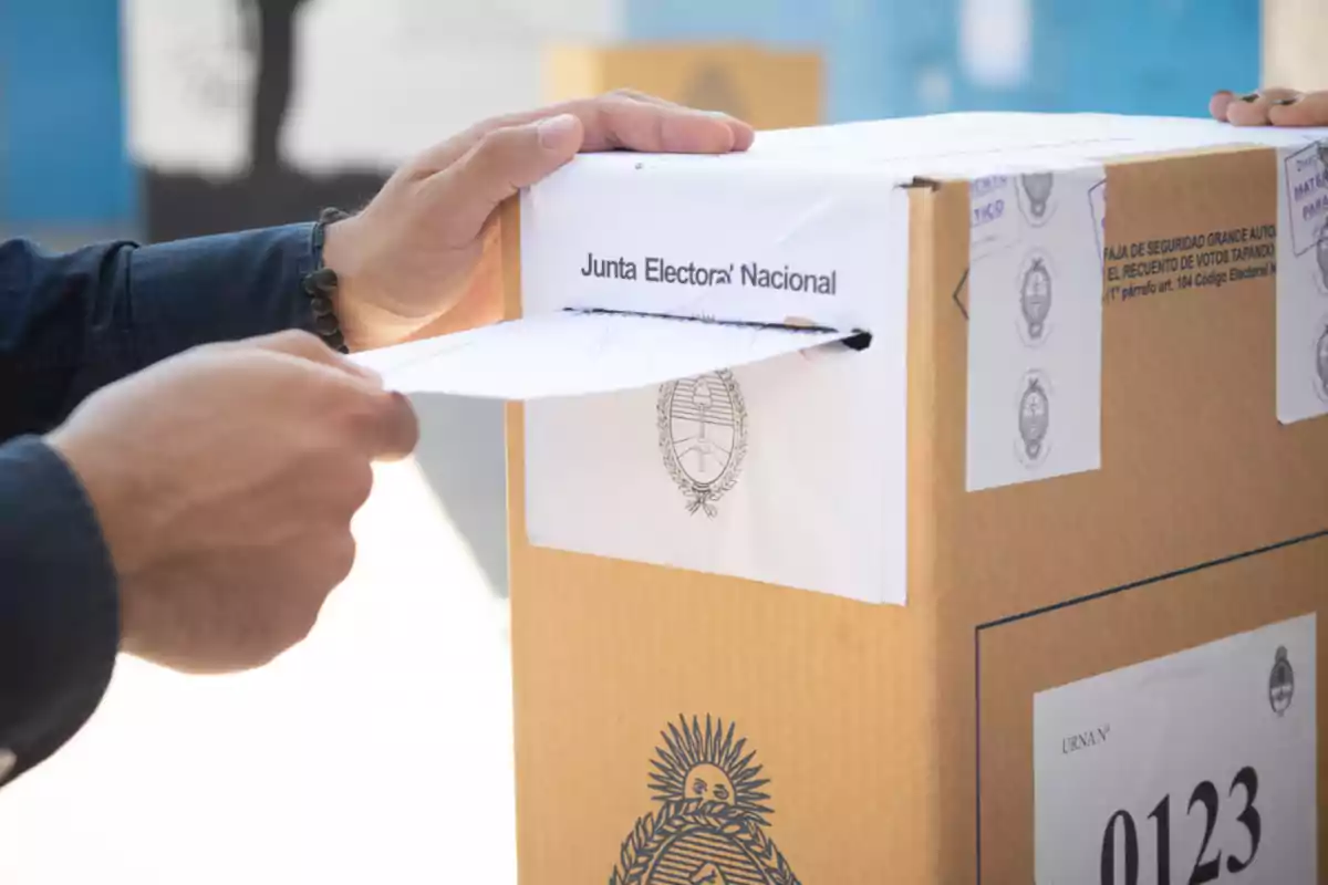 A person inserts an envelope into a ballot box during an electoral process in Argentina.