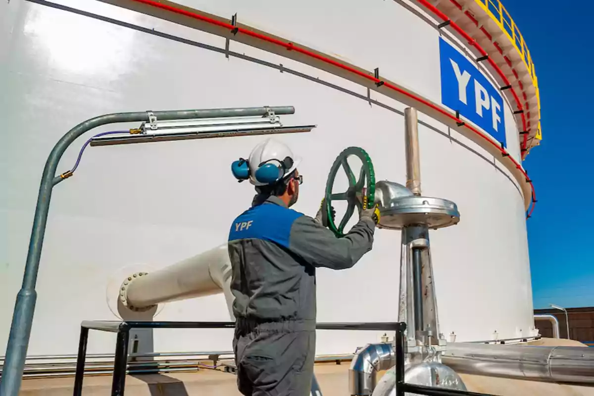 YPF worker operating a valve at an industrial facility.