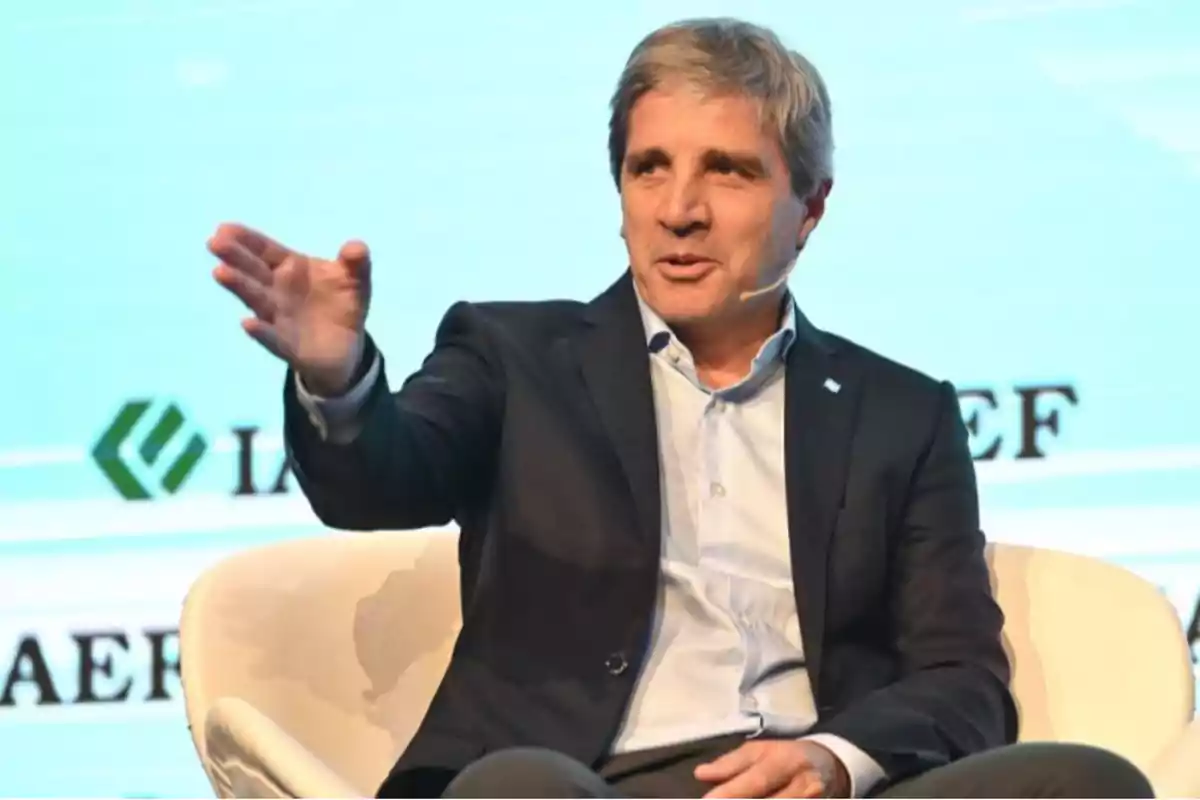 A man in a suit speaking at an event with a headset microphone. A man in a suit speaking at an event with a headset microphone.