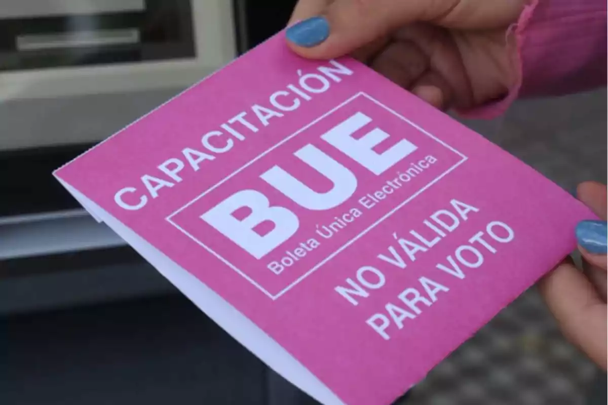 Una persona sostiene un papel rosa que dice Una persona sostiene un papel rosa que dice