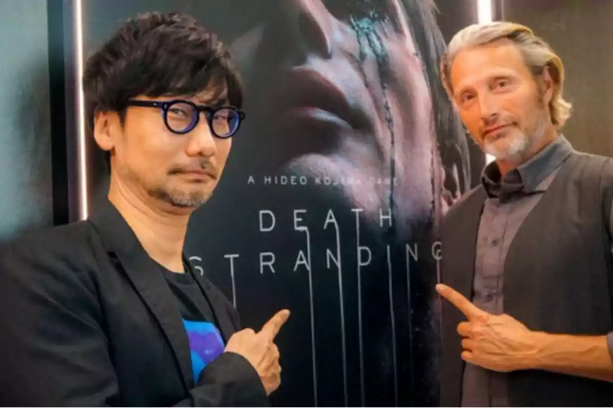 Dos personas posan frente a un cartel del videojuego Dos personas posan frente a un cartel del videojuego