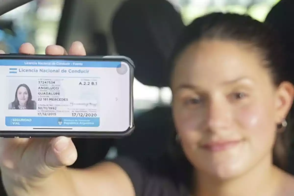 Una persona sostiene un teléfono móvil que muestra una licencia de conducir digital de Argentina.