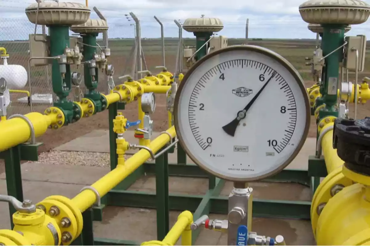 Large pressure gauge showing the pressure in an outdoor industrial installation with yellow and green pipes Large pressure gauge showing the pressure in an outdoor industrial installation with yellow and green pipes