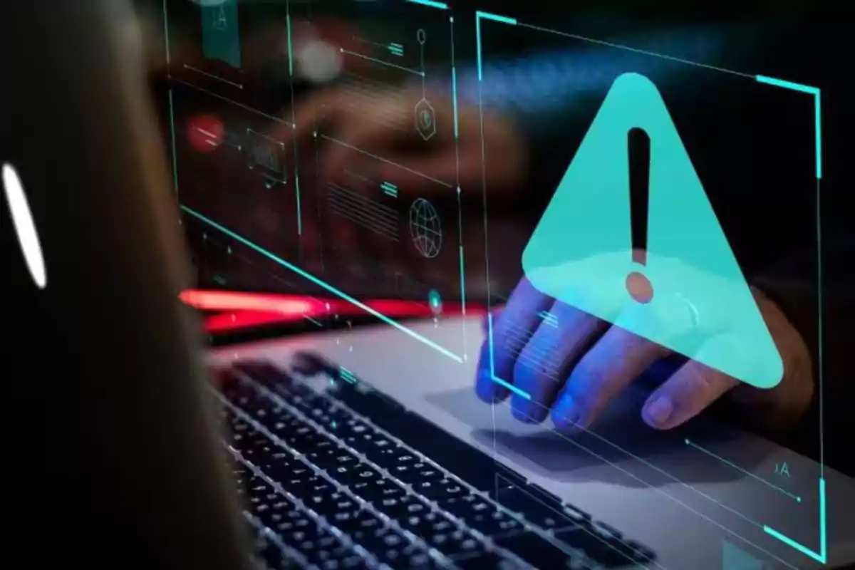 Person using a laptop with a digital warning symbol on the screen