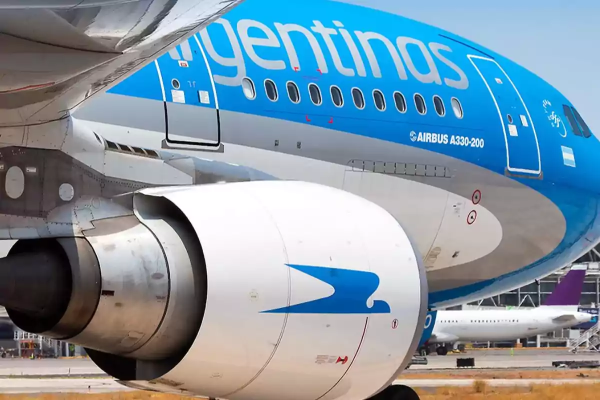 Avión de Aerolíneas Argentinas en pista con el motor y parte del fuselaje visibles Avión de Aerolíneas Argentinas en pista con el motor y parte del fuselaje visibles