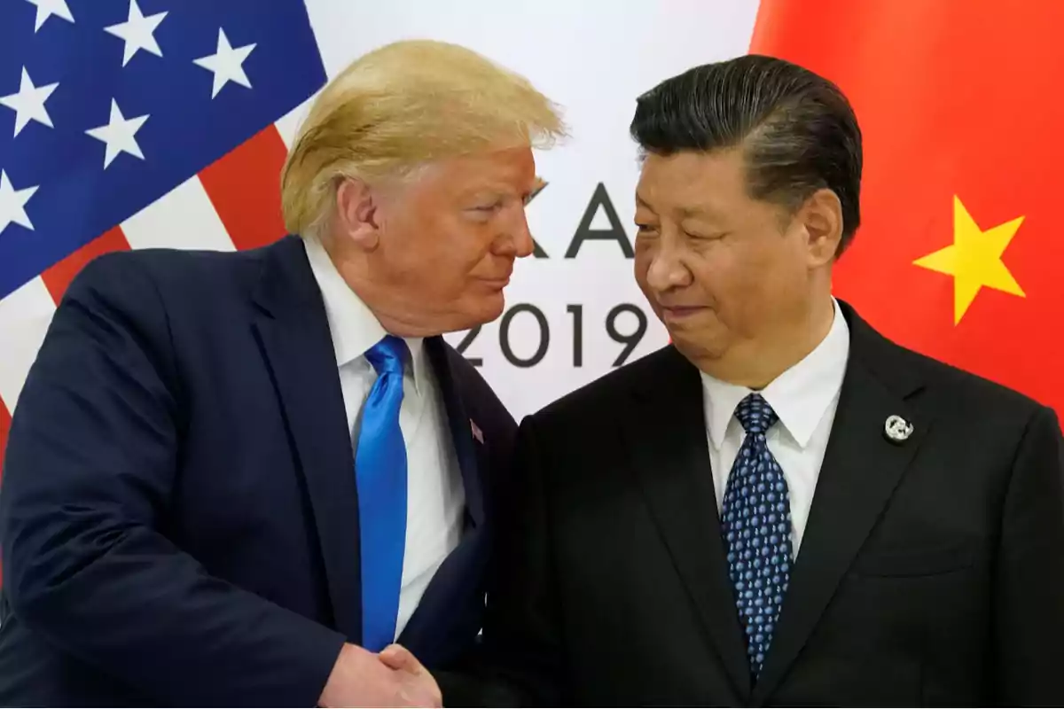 Dos hombres de traje se dan la mano frente a las banderas de Estados Unidos y China