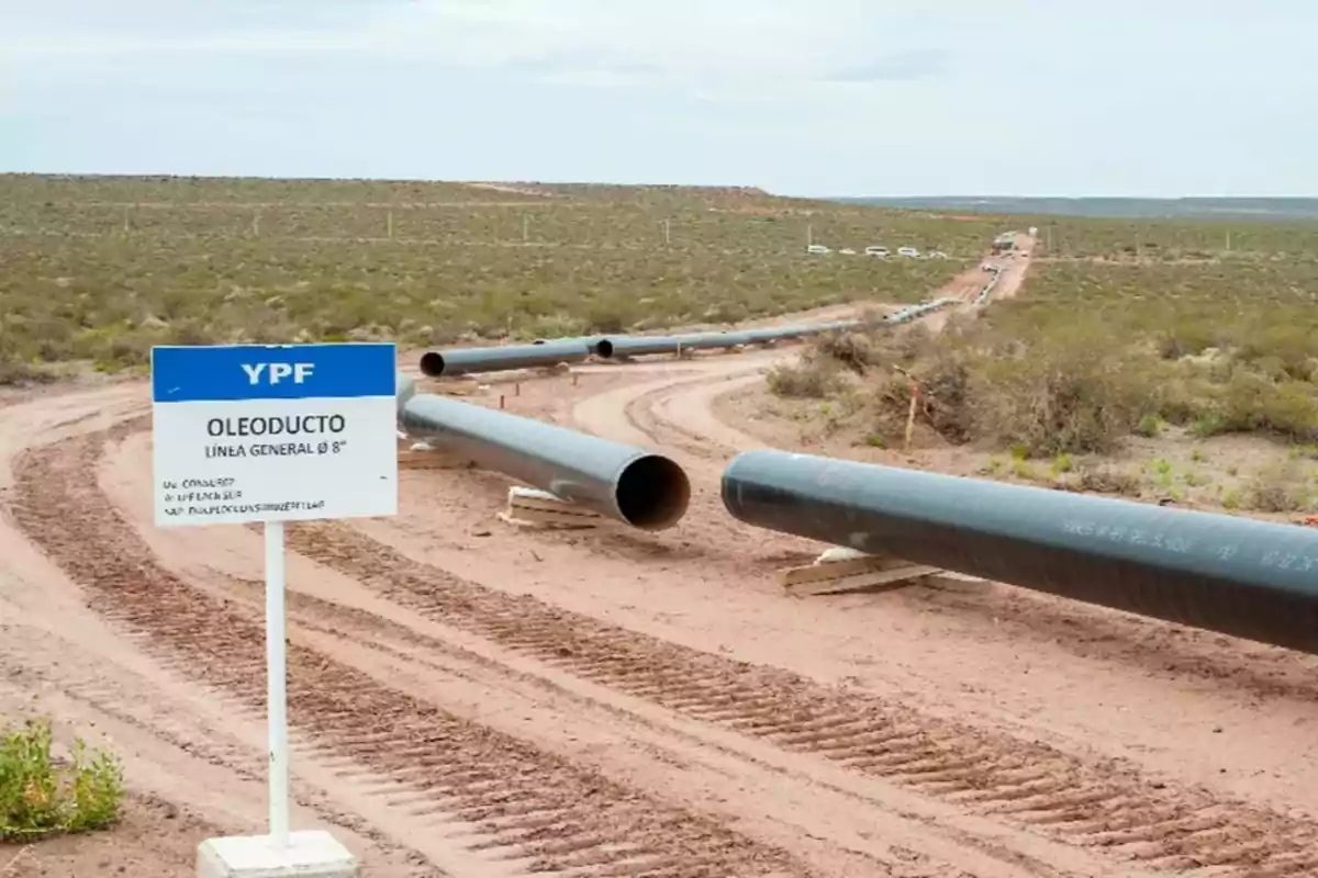 Pipeline pipes above ground in a desert area with a YPF sign indicating the construction work Pipeline pipes above ground in a desert area with a YPF sign indicating the construction work