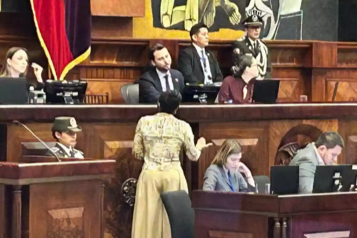 People working and talking in a parliamentary chamber with computers and official uniforms People working and talking in a parliamentary chamber with computers and official uniforms