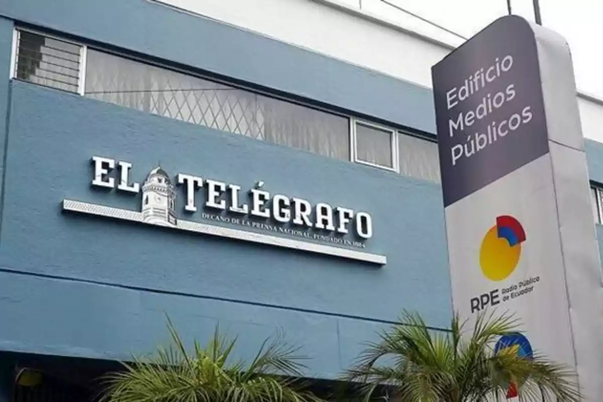 Facade of a blue building with the sign El Telégrafo and a poster that says Public Media Building next to the logo of Ecuador Public Radio Facade of a blue building with the sign El Telégrafo and a poster that says Public Media Building next to the logo of Ecuador Public Radio