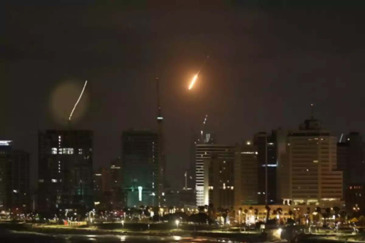 Skyscrapers of a city at night with lights and a projectile in the sky