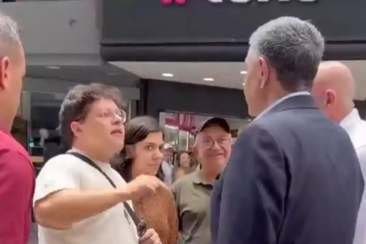 Un grupo de personas conversando en un centro comercial.