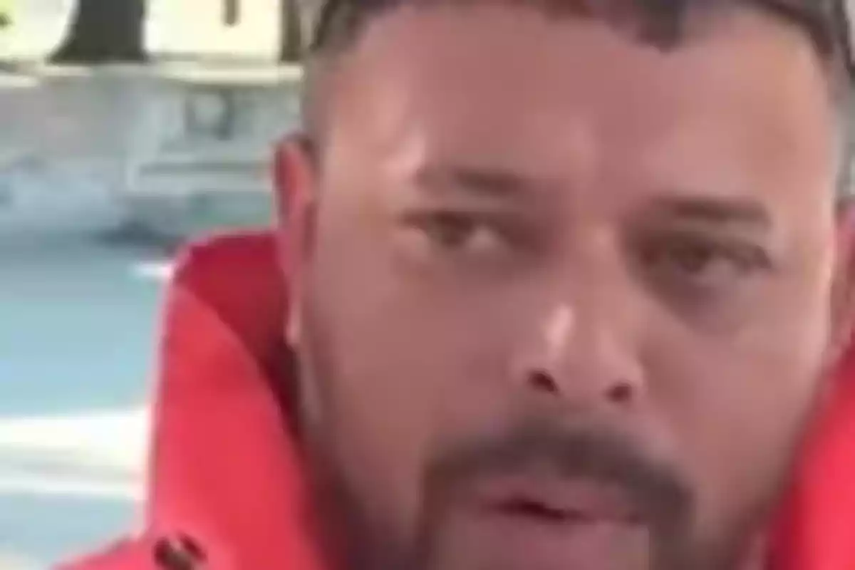 Primer plano de un hombre con barba y chaqueta roja mirando hacia un lado Primer plano de un hombre con barba y chaqueta roja mirando hacia un lado