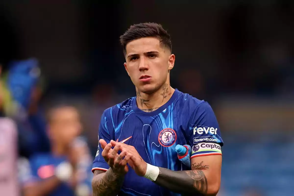 Soccer player in a blue Chelsea uniform applauding on the field during a match