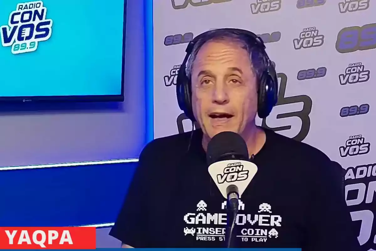 Hombre con auriculares hablando en un micrófono en un estudio de radio.