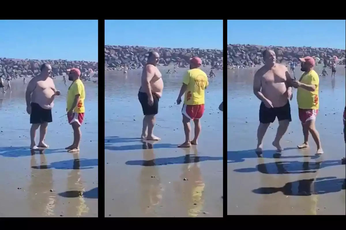 Dos personas conversan en la orilla de una playa, una de ellas lleva una camiseta amarilla y la otra está sin camiseta.