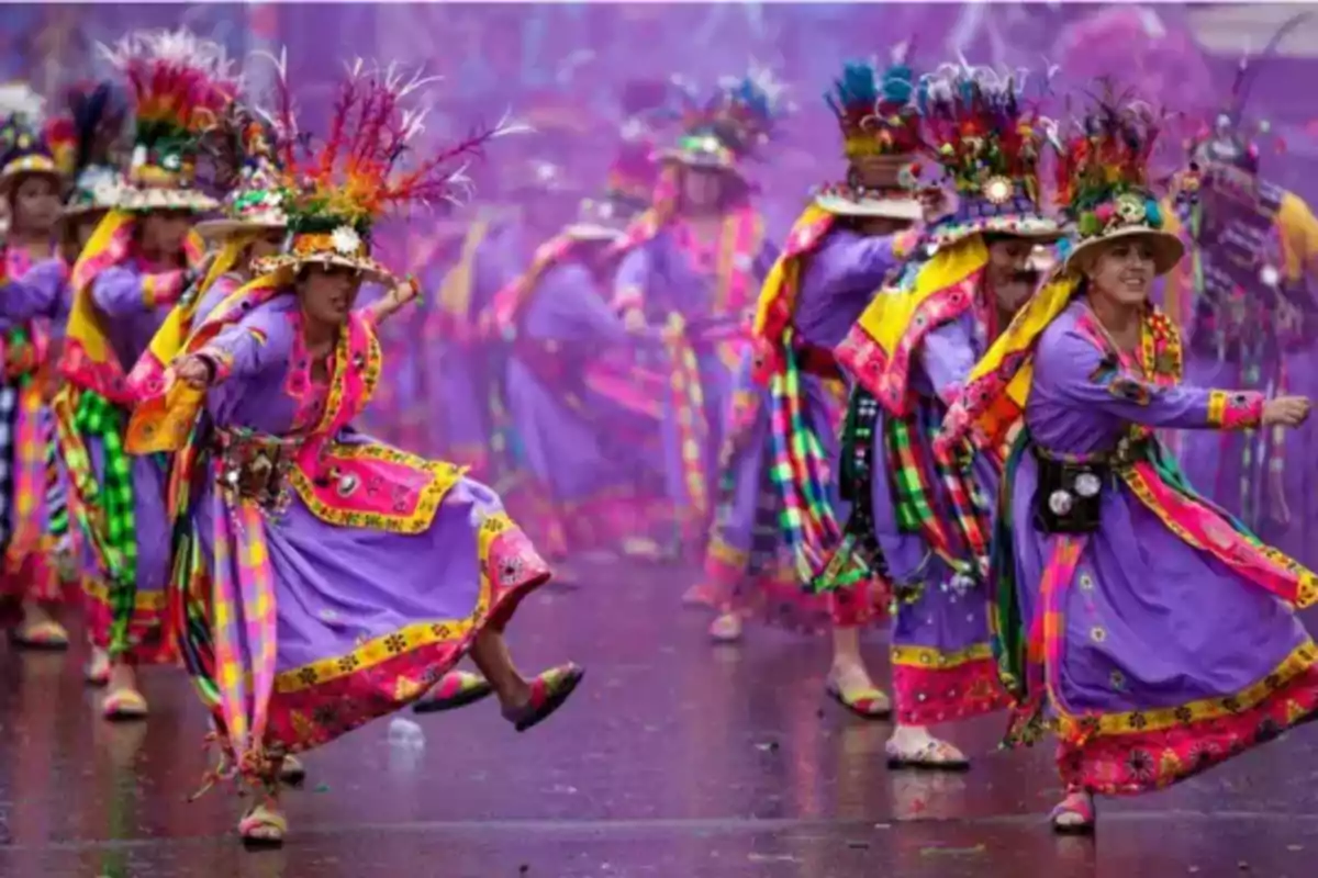 Personas vestidas con trajes tradicionales coloridos bailando en un festival cultural.