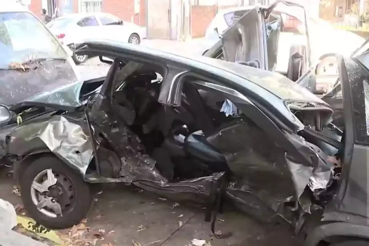 Black car with severe damage on the left side after an accident on the public road