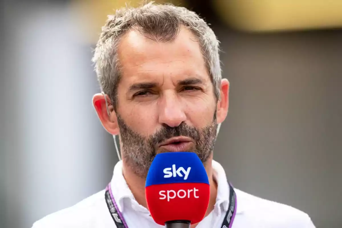 Gray-haired, bearded man holding a Sky Sport microphone while speaking in front of the camera Gray-haired, bearded man holding a Sky Sport microphone while speaking in front of the camera