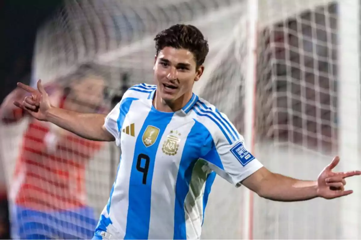 Soccer player wearing an Argentina jersey celebrating a goal in front of the goalpost Soccer player wearing an Argentina jersey celebrating a goal in front of the goalpost