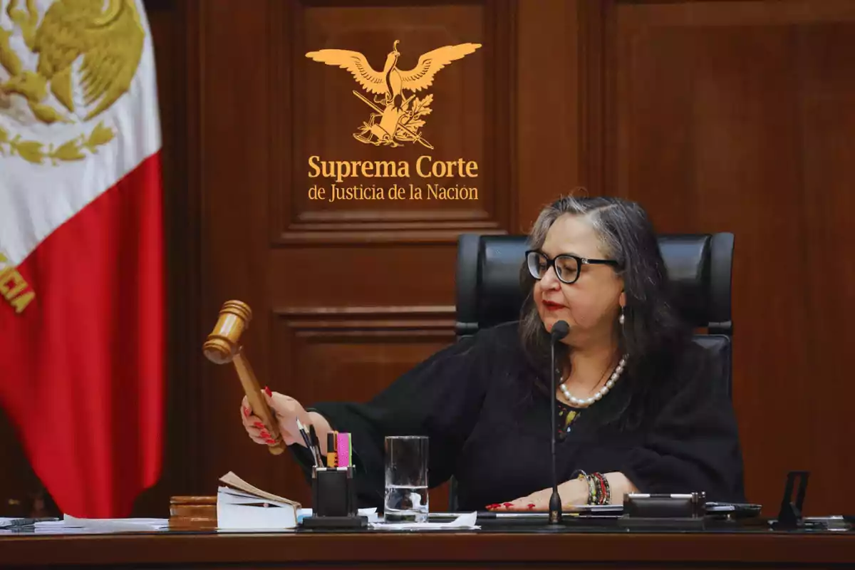 Judge sitting at her desk holding a gavel in a courtroom of the Supreme Court of Justice of the Nation of Mexico with the national flag in the background Judge sitting at her desk holding a gavel in a courtroom of the Supreme Court of Justice of the Nation of Mexico with the national flag in the background