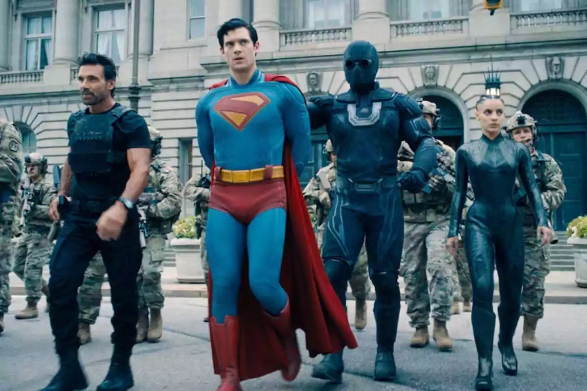 A group of people in superhero and military costumes walk down a street in front of an old building. A group of people in superhero and military costumes walk down a street in front of an old building.