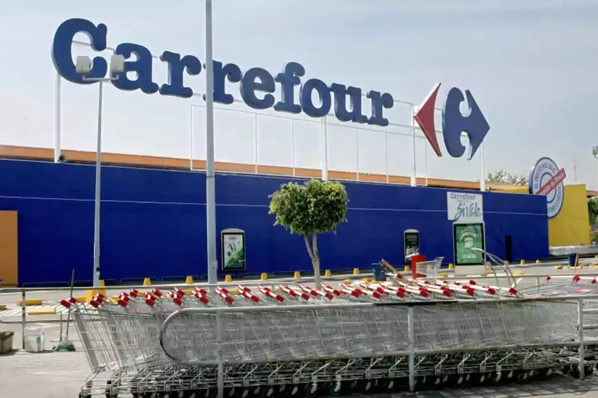 Un grupo de carritos de supermercado está alineado frente a un edificio con el logotipo de una tienda. Un grupo de carritos de supermercado está alineado frente a un edificio con el logotipo de una tienda.