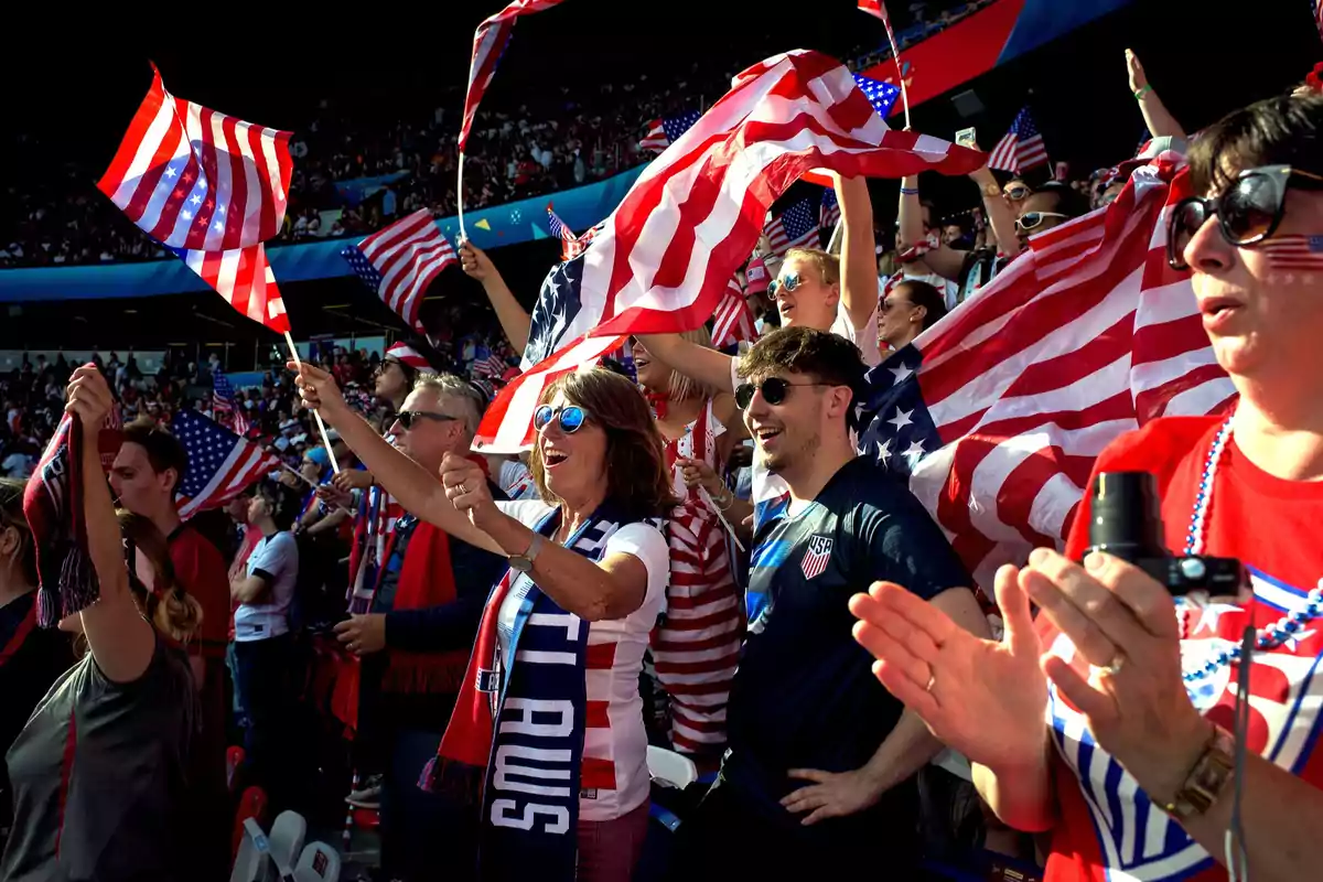 Fans cheering in a stadium with United States flags and clothing in patriotic colors Fans cheering in a stadium with United States flags and clothing in patriotic colors