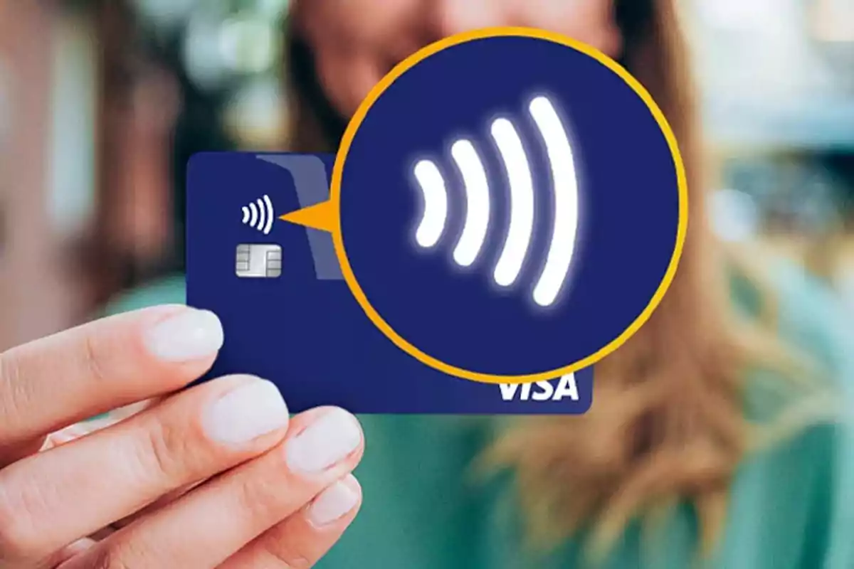 Person holding a credit card with highlighted contactless payment technology. Person holding a credit card with highlighted contactless payment technology.