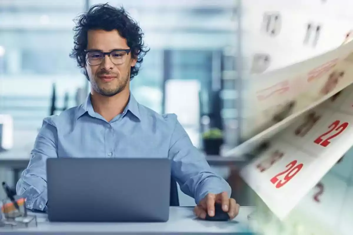 Hombre con gafas trabajando en una computadora portátil con un calendario en el fondo consultando si tiene que trabajar el primero de enero, Año Nuevo.