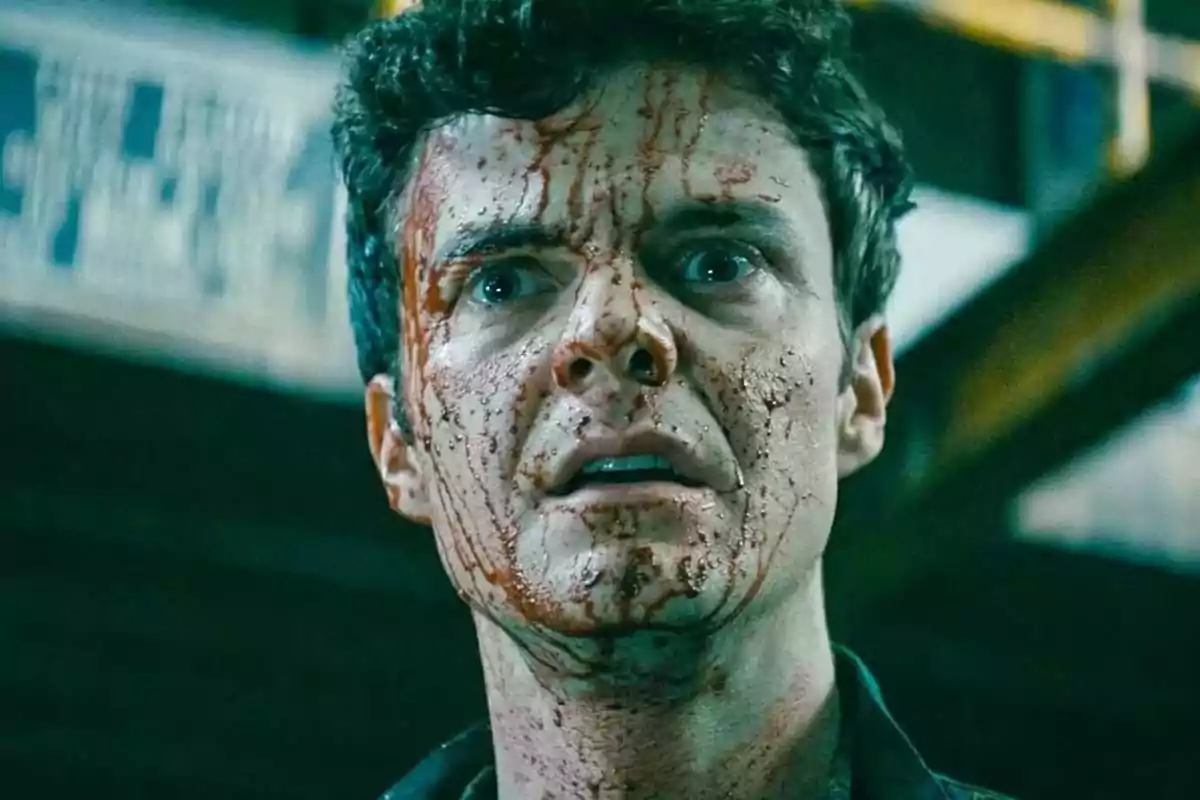 A man with a face covered in blood and an expression of surprise or fear in a dark setting. A man with a face covered in blood and an expression of surprise or fear in a dark setting.
